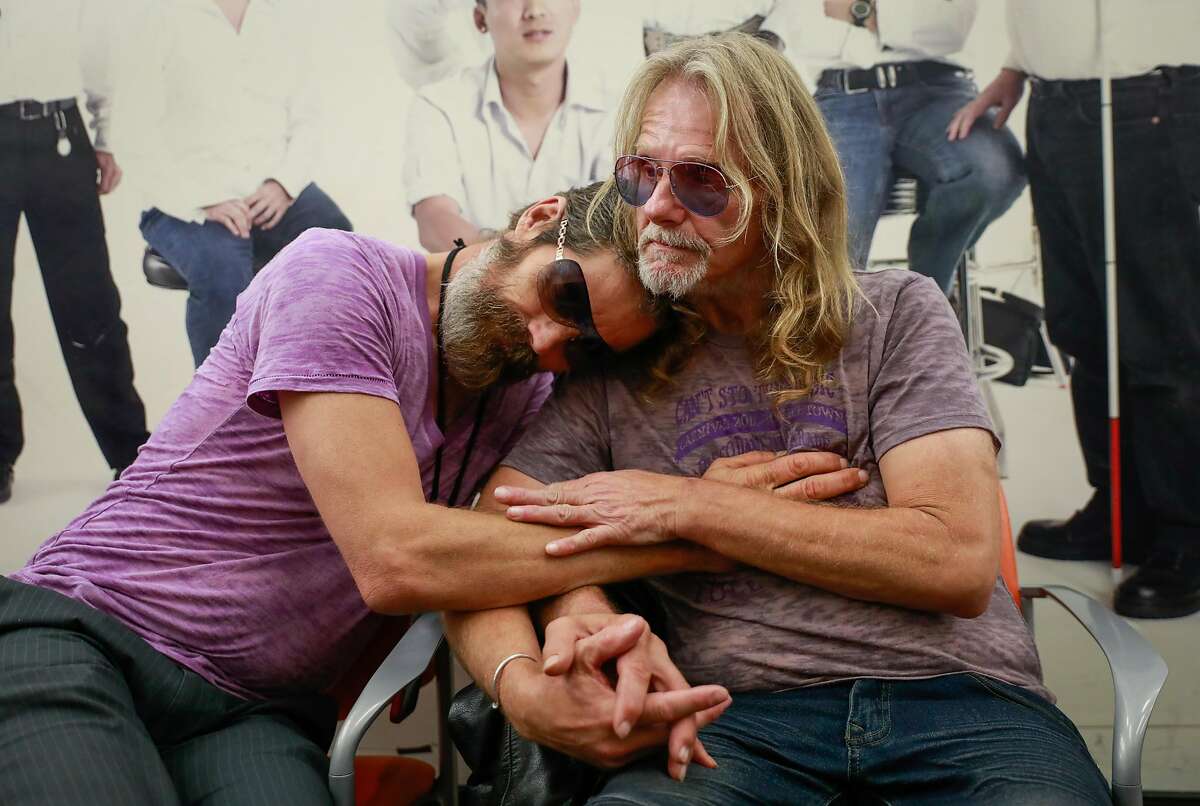 Robert Fleischaur and partner Rickey Lee (right) embrace at Ward 86 as they wait for an appointment at the Zuckerberg San Francisco Hospital in San Francisco, California, on Tuesday, Sept. 10, 2019. They both have HIV.