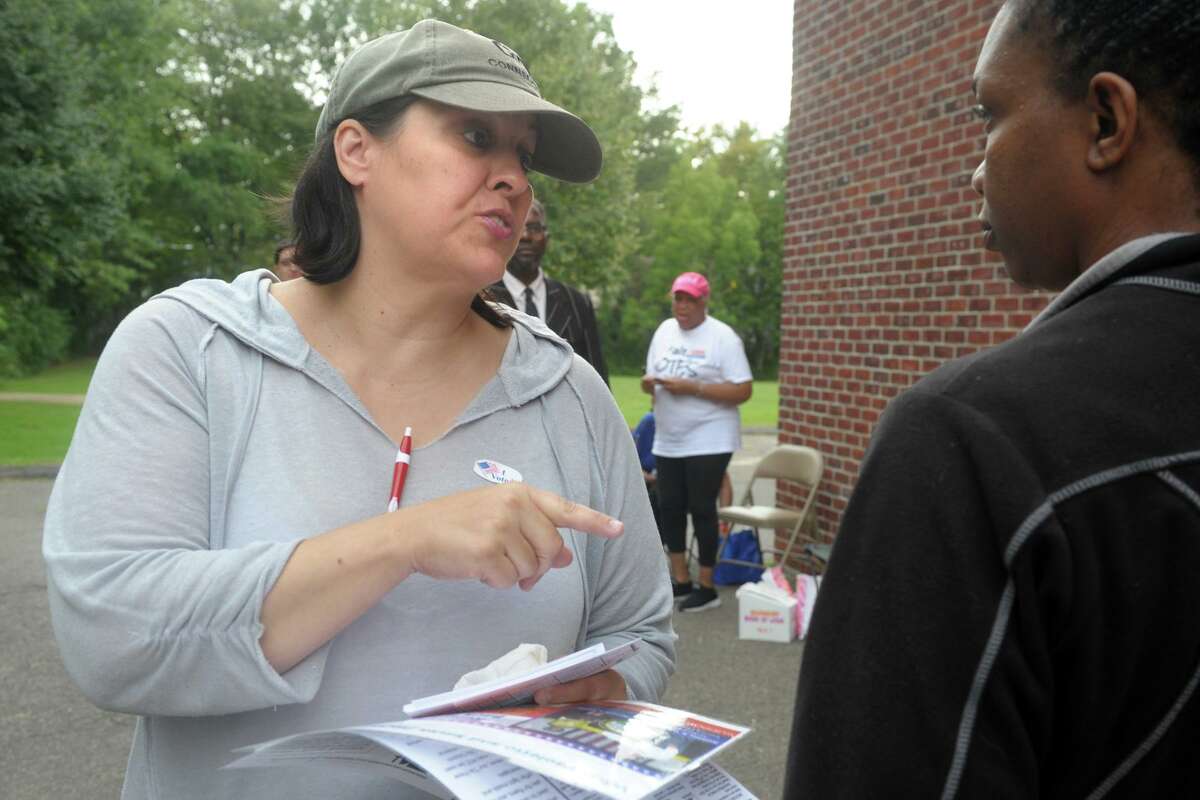 Maria Pereira, a democratic petition candidate for Bridgeport’s City Council seat in the 138th District, greets voters arriving to vote in Tuesday’s primary elections at Thomas Hooker School, in Bridgeport, Conn. Sept. 10, 2019.