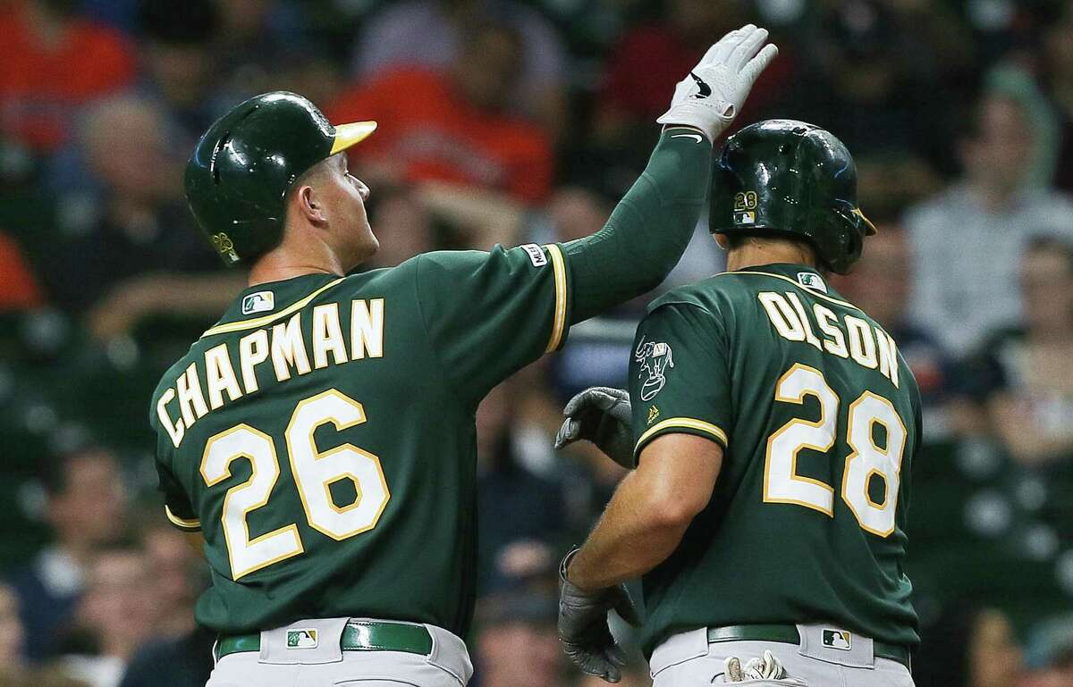 HOUSTON, TEXAS - SEPTEMBER 10: Matt Chapman #26 of the Oakland Athletics taps Matt Olson #28 on his head after Olson hit a home run in the fourth inning against the Houston Astros at Minute Maid Park on September 10, 2019 in Houston, Texas. (Photo by Bob Levey/Getty Images)