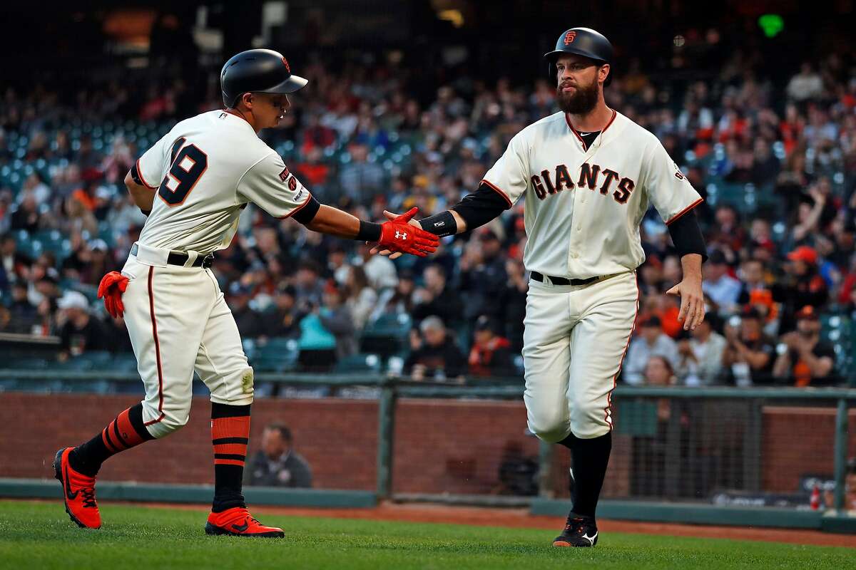 San Francisco Giants' Brandon Belt and Mauricio Dubon slap hands after scoring on Stephen Vogt's single in 1st inning against Pittsburgh Pirates during MLB game at Oracle Park in San Francisco, Calif., on Tuesday, September 10, 2019.