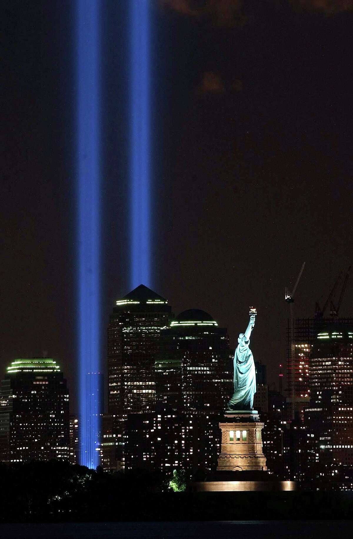 The Tribute in Light shines over the Manhattan skyline and the Statue of Liberty in New York on Sept. 11, 2004.