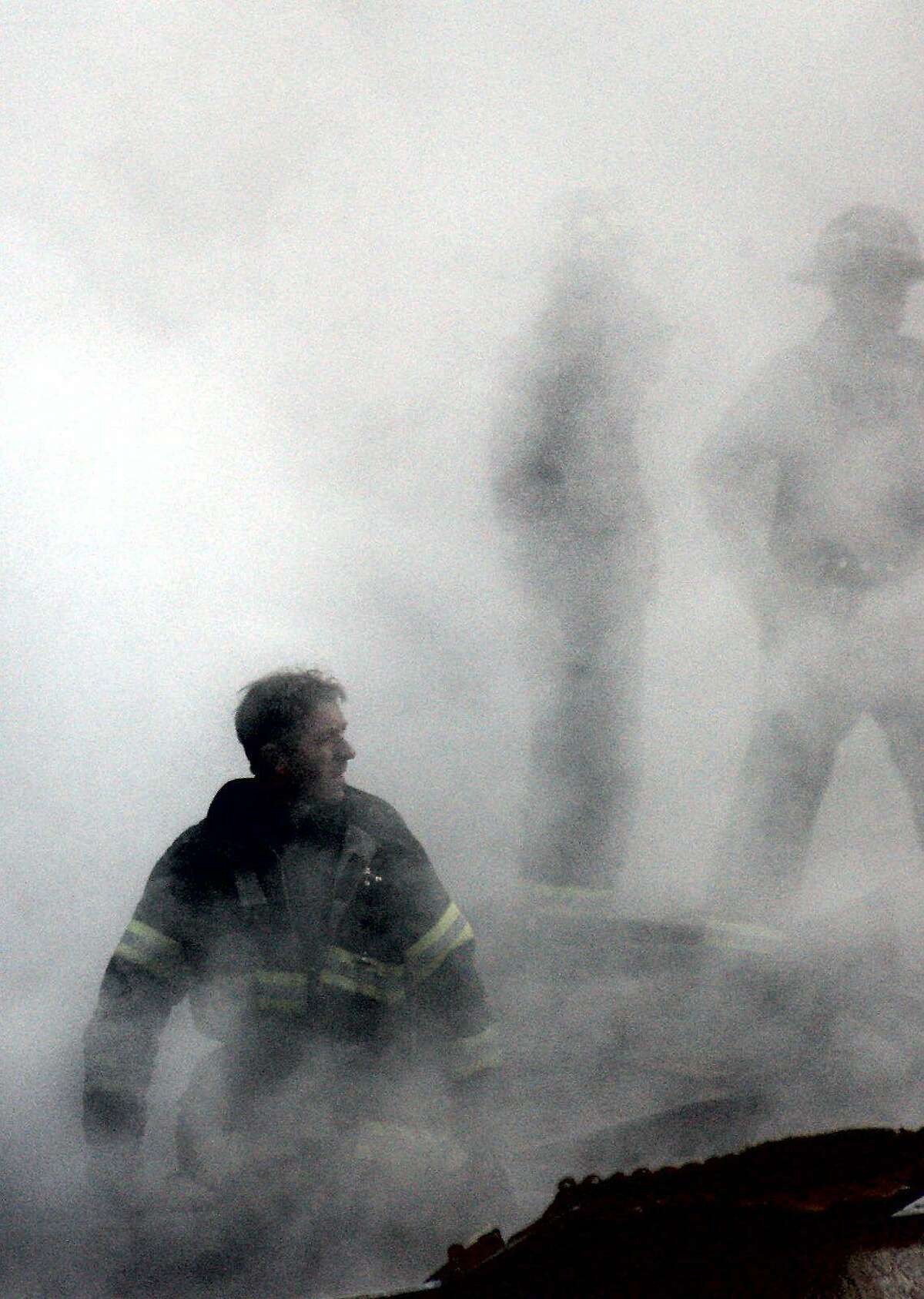 In this Sept. 14, 2001 file photo, a firefighter emerges from the smoke and debris of the World Trade Center in New York.