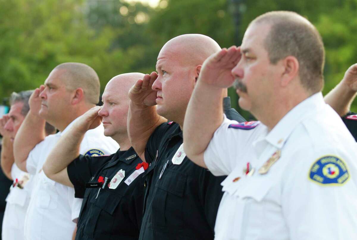 Firefighters salute the American flag during a ceremony in honor of Patriot Day at The Woodlands Central Fire Station on Tuesday, Sept. 11, 2019, in Spring. The event was held in remembrance of the nearly 3,000 victims of the terror attacks on September 11, 2001.