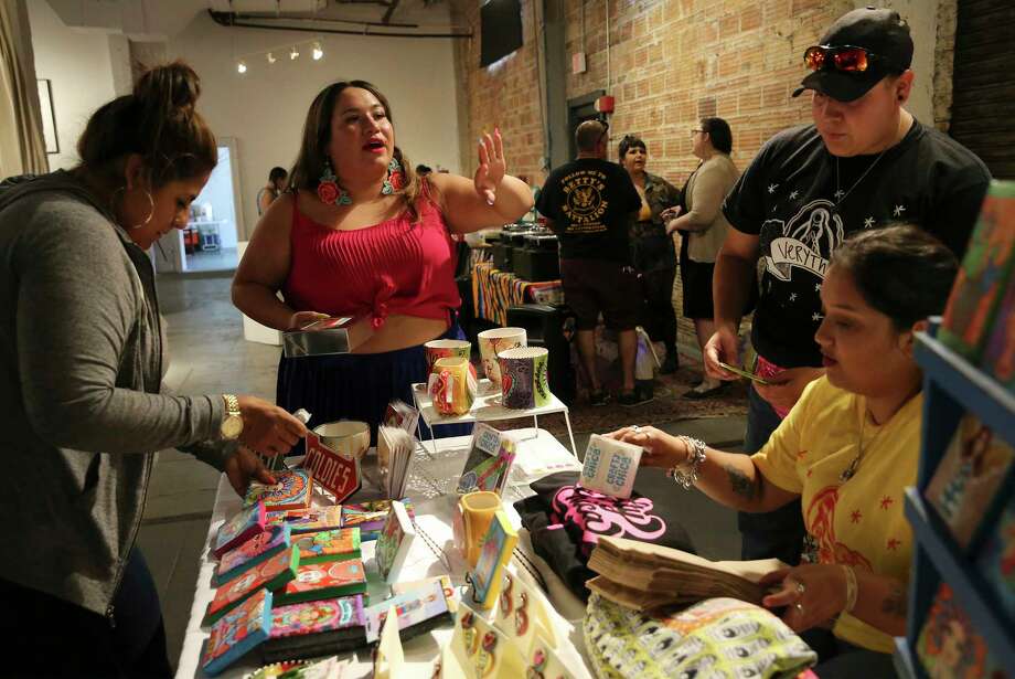Cristina M. Martinez of the "Very That" brand, center, goes over details at a vendor's booth at a recent event she co-hosted with local influencer Melanie Mendez-Gonzales of "Que Means What" at Brick in the Blue Star Arts Complex. They invited Kathy Cano-Murillo from Phoenix, creator of The Crafty Chica, to speak to the San Antonio community. (Kin Man Hui/San Antonio Express-News) Photo: Kin Man Hui, Staff Photographer / ©2019 San Antonio Express-News