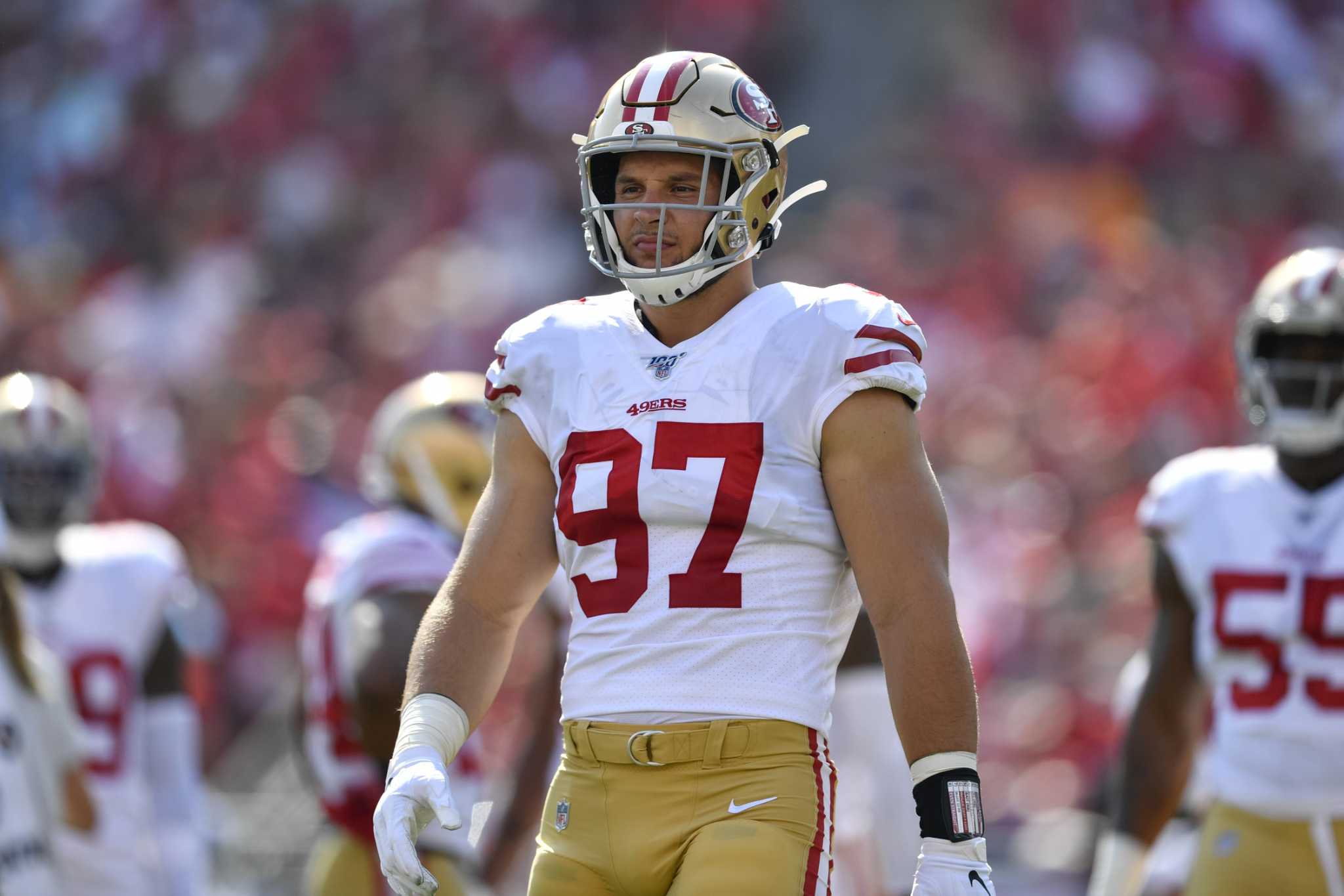 San Francisco 49ers first-round pick Nick Bosa, center, holds up a jersey  next to his mother Cheryl, left, and father John during an NFL football  news conference, Friday, April 26, 2019, in