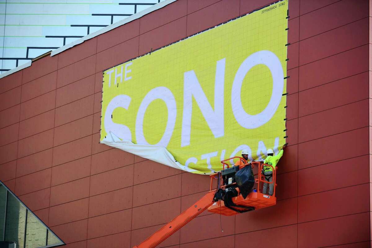 Construction workers with Brookfield Properties remove a banner for the SoNo Collection Mall Wednesday, September 11, 2019, in Norwalk, Conn. The mall is scheduled to open next month.
