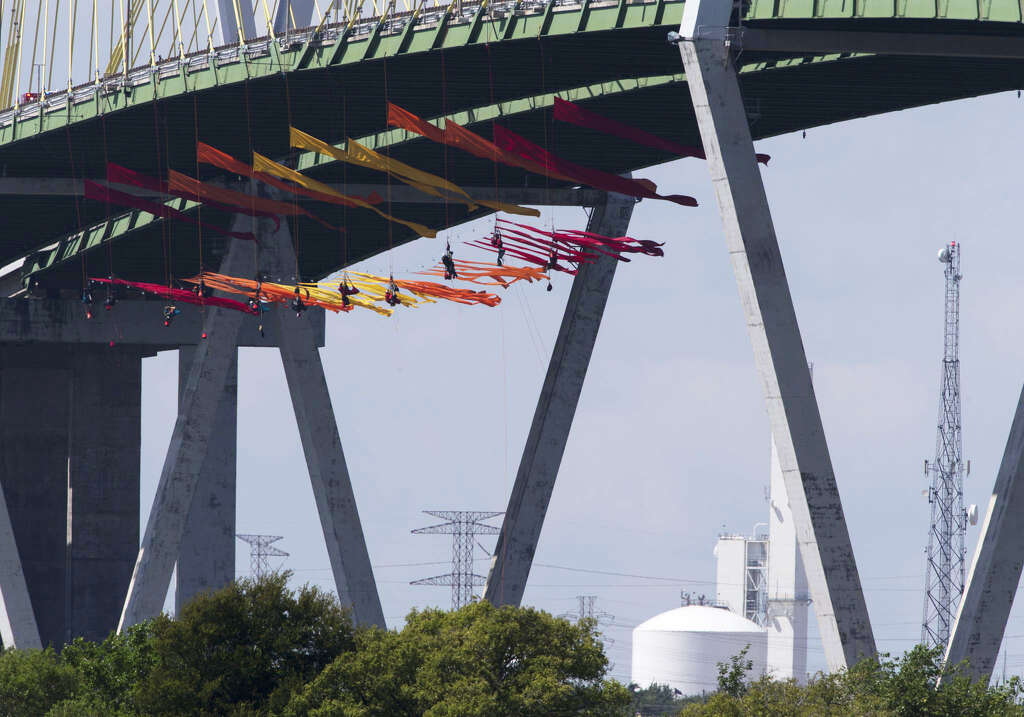 <p>Eleven Greenpeace USA protesters are dangling from the northbound of the Fred Hartman Bridge to protest against the oil industry on Thursday, Sept. 12, 2019, in Baytown. Another 11 spotter for those protesters</p>