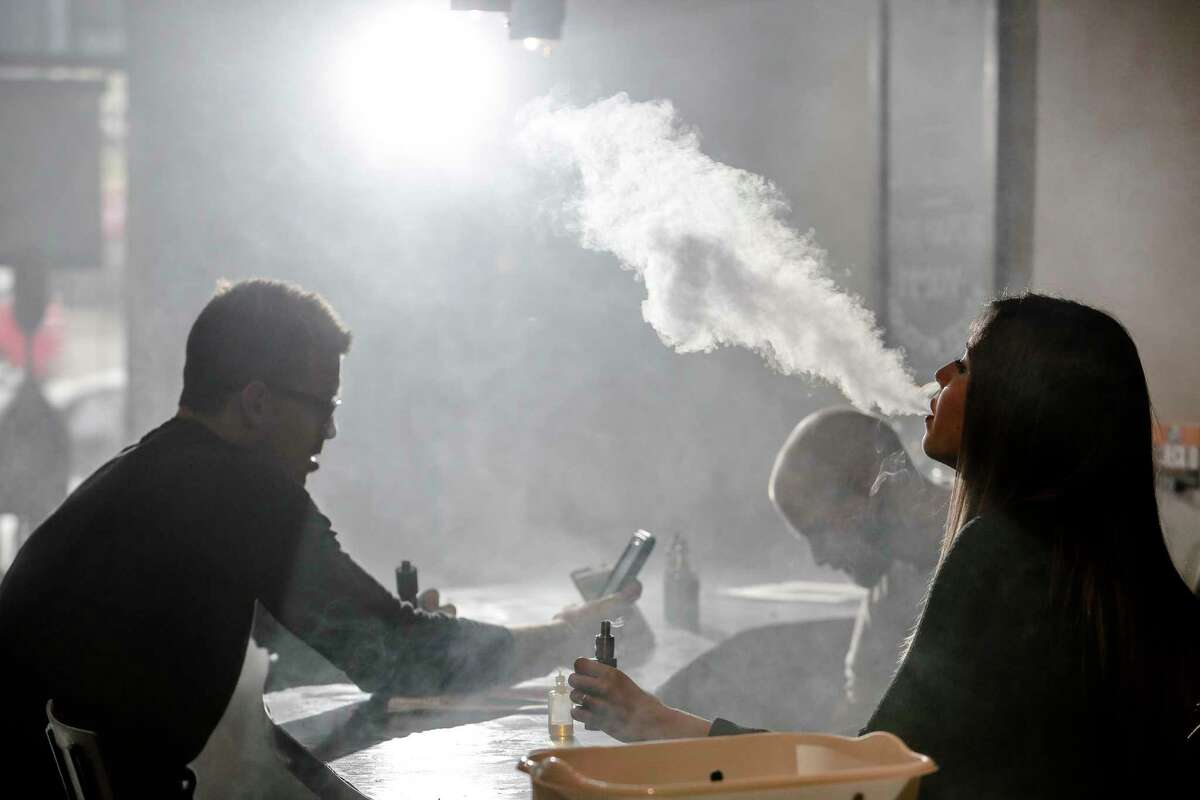 New Element Fine Vapors employee Melissa Torres, right, vapes with Nate Pingor, left, and owner Daniel Adell in the shop Monday, Oct. 26, 2015, in Houston.