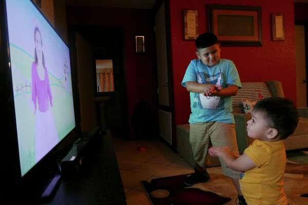 Luis Jr., top, and his brother, Luke Anthony Fabela, perform “Baby Shark” with a video at home. The family plans to enroll Luke in dual language next year at his day care center.
