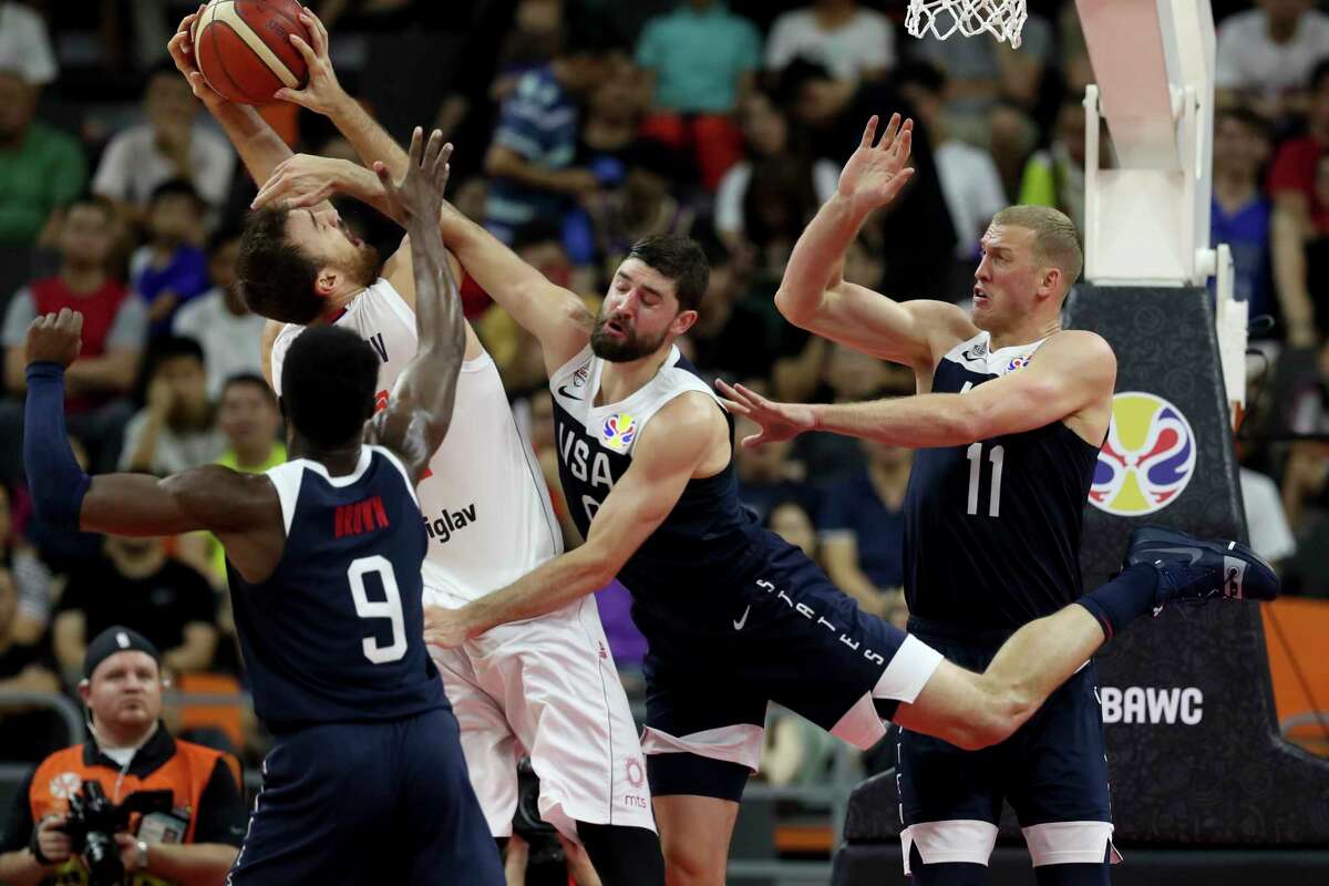 Serbia's Nikola Milutinov keeps the ball away from United States' Jaylen Brown, left, United States' Joe Harris, center and United States' Mason Plumlee at right during a consolation playoff game for the FIBA Basketball World Cup in Dongguan in southern China's Guangdong province on Thursday, Sept. 12, 2019. The U.S. will leave the World Cup with its worst finish ever in a major international tournament, assured of finishing no better than seventh after falling to Serbia 94-89 in a consolation playoff game on Thursday night. (AP Photo/Ng Han Guan)