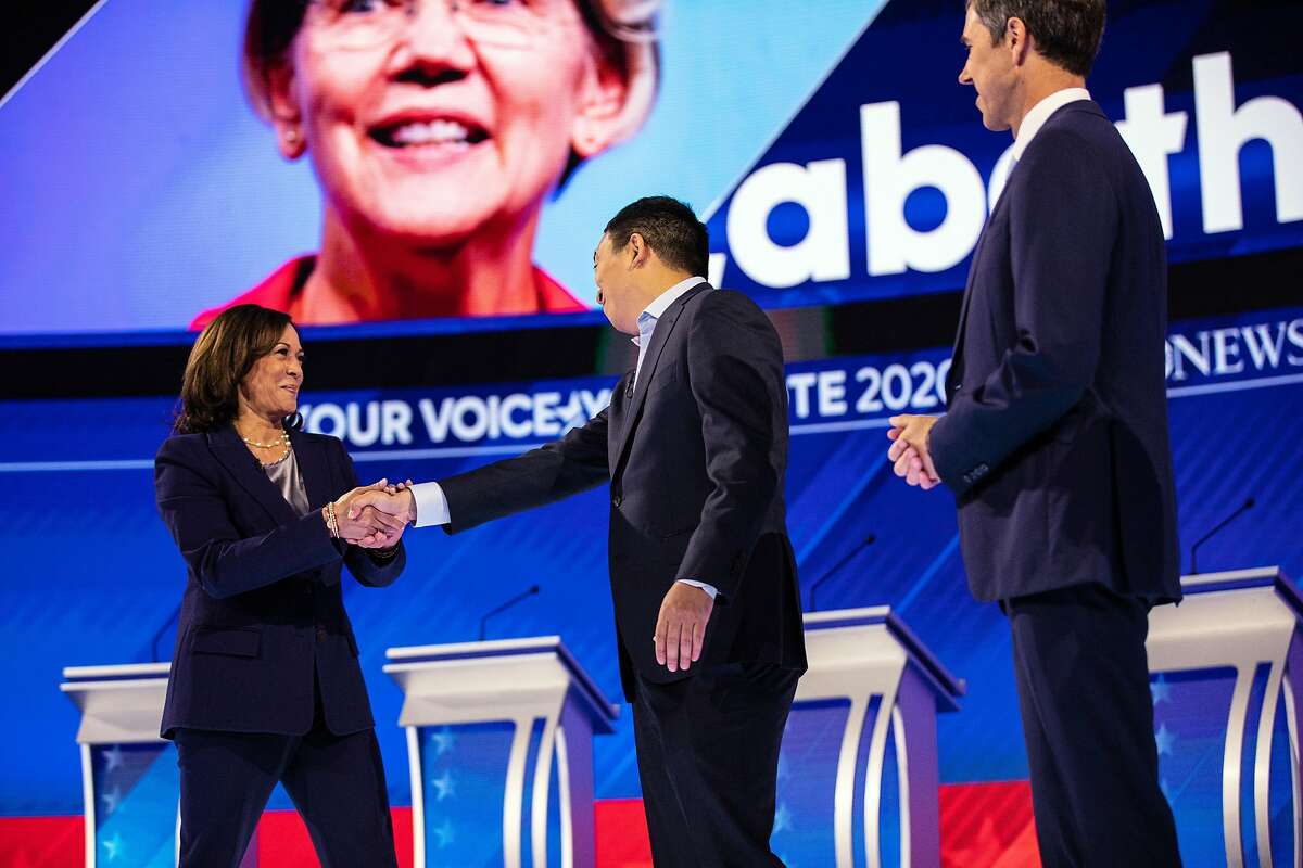 FILE - Sen. Kamala Harris (D-Calif.) greets the entrepreneur Andrew Yang at the start of the Democratic Party presidential debate at Texas Southern University in Houston on Thursday, Sept. 12, 2019. At right is former Rep. Beto O'Rourke of Texas.