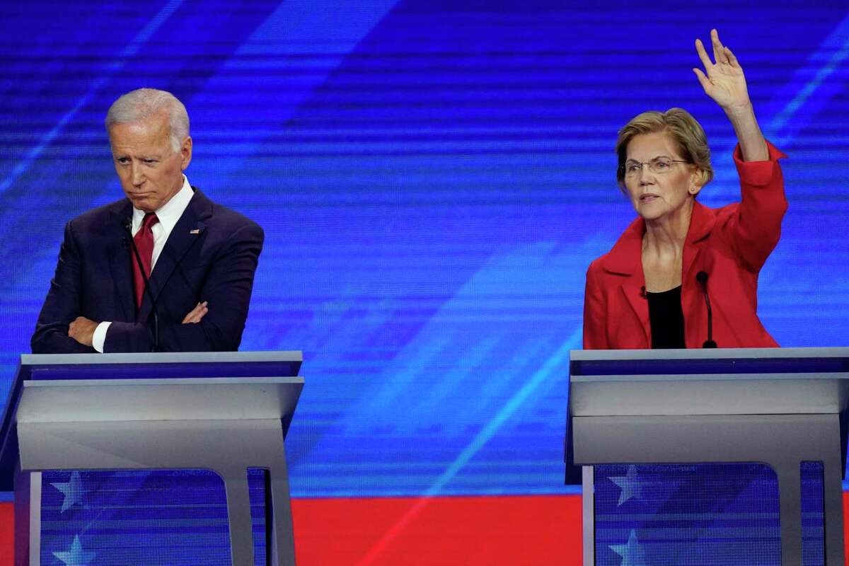 Former Vice President Joe Biden, left, and Sen. Elizabeth Warren, D-Mass., right, Thursday, Sept. 12, 2019, listen during a Democratic presidential primary debate hosted by ABC at Texas Southern University in Houston. (AP Photo/David J. Phillip)