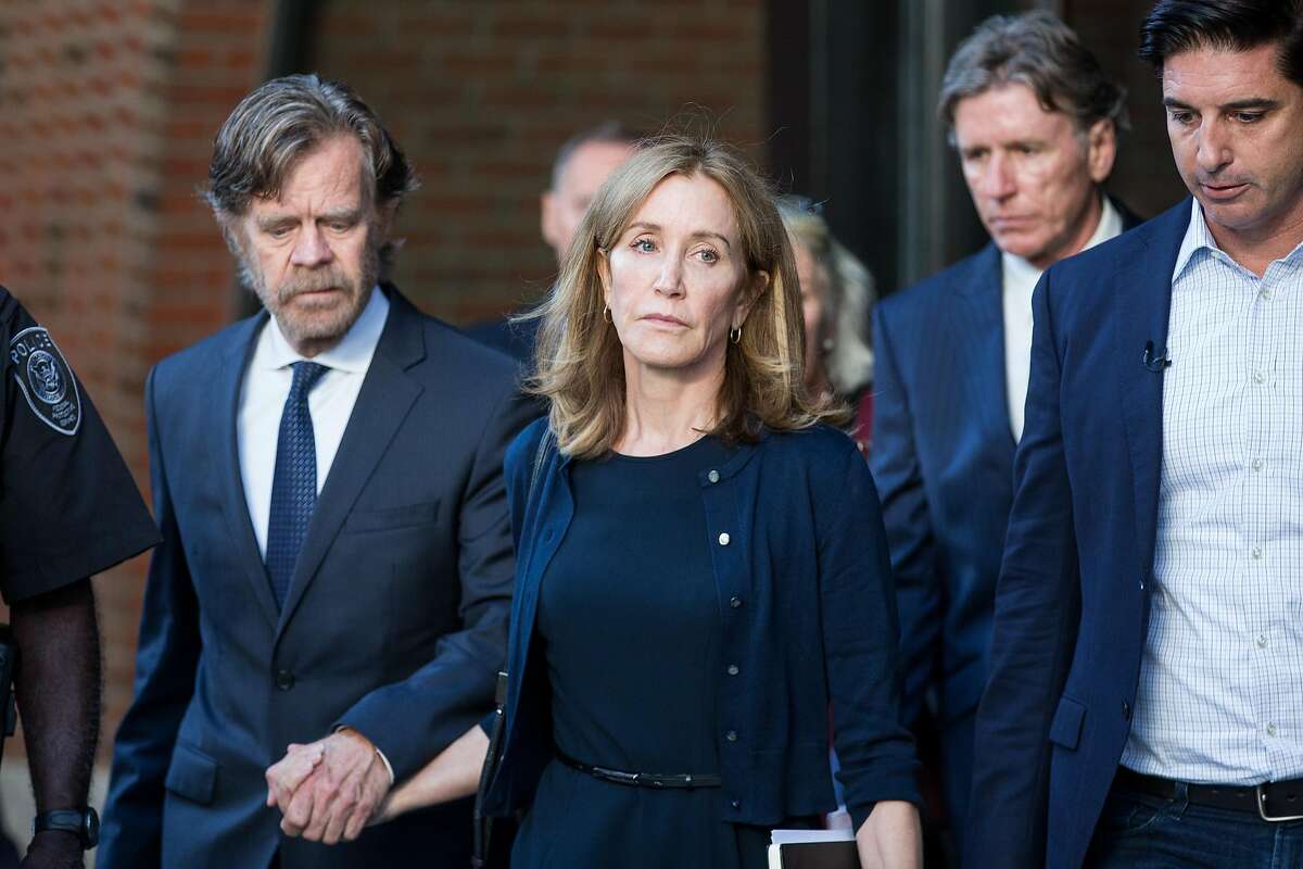 The actress Felicity Huffman leaves federal court beside her husband, the actor William Macy, after her sentencing in Boston, on Friday, Sept. 13, 2019. Huffman was sentenced to 14 days in prison for paying a college consultant $15,000 to inflate her daughter’s SAT score, becoming the first parent given a punishment in a sweeping scheme in which nearly three dozen wealthy parents are accused of using lies and bribes to smooth their children’s way into prestigious colleges. (Scott Eisen/The New York Times)