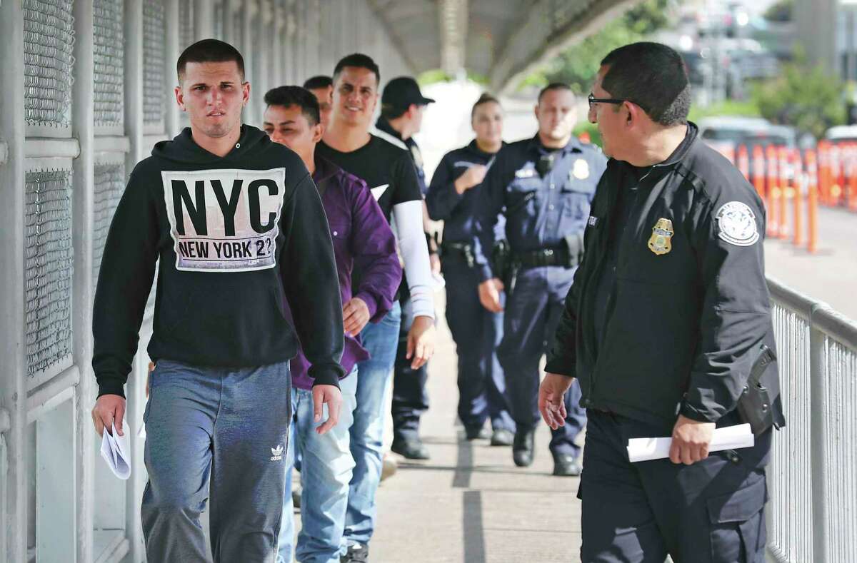 U.S. Immigration and Customs Enforcement officials return six Cuban men and one from Honduras to Mexican Immigration officials in the middle of the Gateway to the Americas International Bridge between Laredo and Nuevo Laredo on Friday, Sept. 13, 2019. The men, seeking asylum were given another court date in two months.