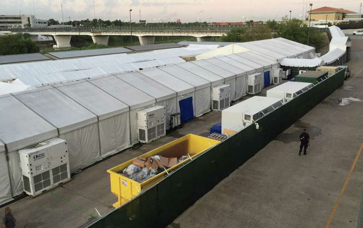 The tents set up in Laredo, Tx., where migrants seeking asylum are taken for a court hearing through live video stream with an immigration judge in San Antonio. Migrants are escorted to the holding tents though an enclosed walkway, at top right, leading from the U.S. side of the Gateway to the Americas International Bridge.