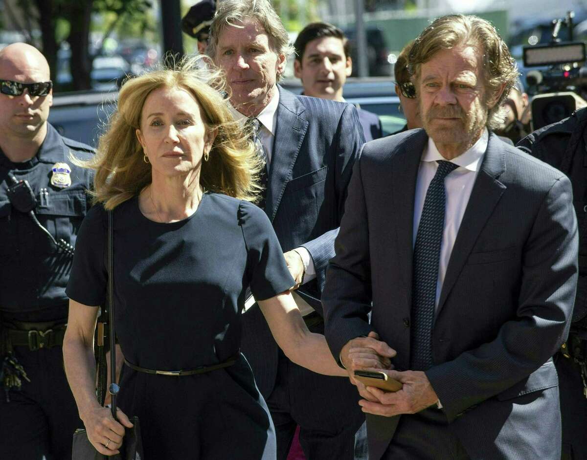 Actress Felicity Huffman, escorted by her husband William H. Macy, makes her way to the entrance of the John Joseph Moakley United States Courthouse September 13, 2019 in Boston, where she will be sentenced for her role in the College Admissions scandal. - Huffman, one of the defendants charged in the college admissions cheating scandal, is scheduled to be sentenced for paying $15,000 to inflate her daughters SAT scores, a crime she said she committed trying to be a good parent. (Photo by Joseph Prezioso / AFP)JOSEPH PREZIOSO/AFP/Getty Images