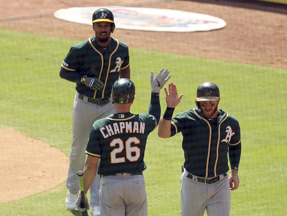 Oakland Athletics Matt Chapman (26) greets Robbie Grossman (8) and Marcus Semien (10) after Semien's two-run home run in the third against the Texas Rangers in a baseball game Sunday, Sept. 15, 2019, in Arlington, Texas. (AP Photo/Richard W. Rodriguez)