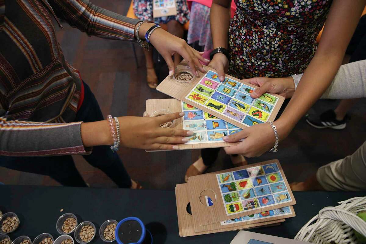 Loteria cards are handed out during the La Lote event at the San Antonio Central Library on Sunday. La Lote featured an afternoon of lotería-inspired art and activities, including interactive readings and lotería games.