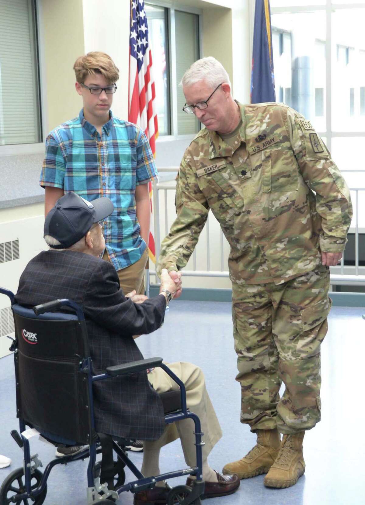 New York Army National Guard Lt. Colonel Doug Baker is congratulated on his promotion by his father, World War II Army Air Forces veteran Almer B. Baker, during a ceremony at New York National Guard Headquarters in Latham. One of Bakeras sonas looks on. (New York Army National Guard)