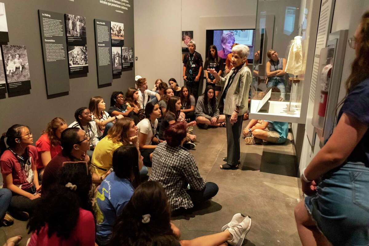 Holocaust survivor Chaja Verveer of Houston, stands next her toddler gown while speaking to local students apart of the Engines of Change student ambassador program at the Holocaust Museum Houston Sunday, Sep 15, 2019, in Houston.