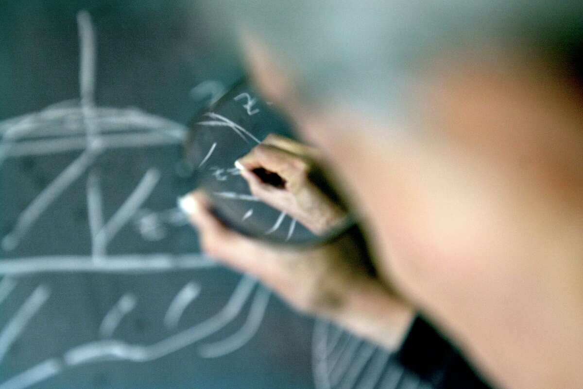 MATH02a-C-26SEP02-DD-CKH CHRISTINA KOCI HERNANDEZ/CHRONICLE Osserman's hand, shot through his glasses, scribbles math problems onto a chalkboard in his office.Robert Osserman, Special Projects Director at the Mathematical Sciences Research Institute.
