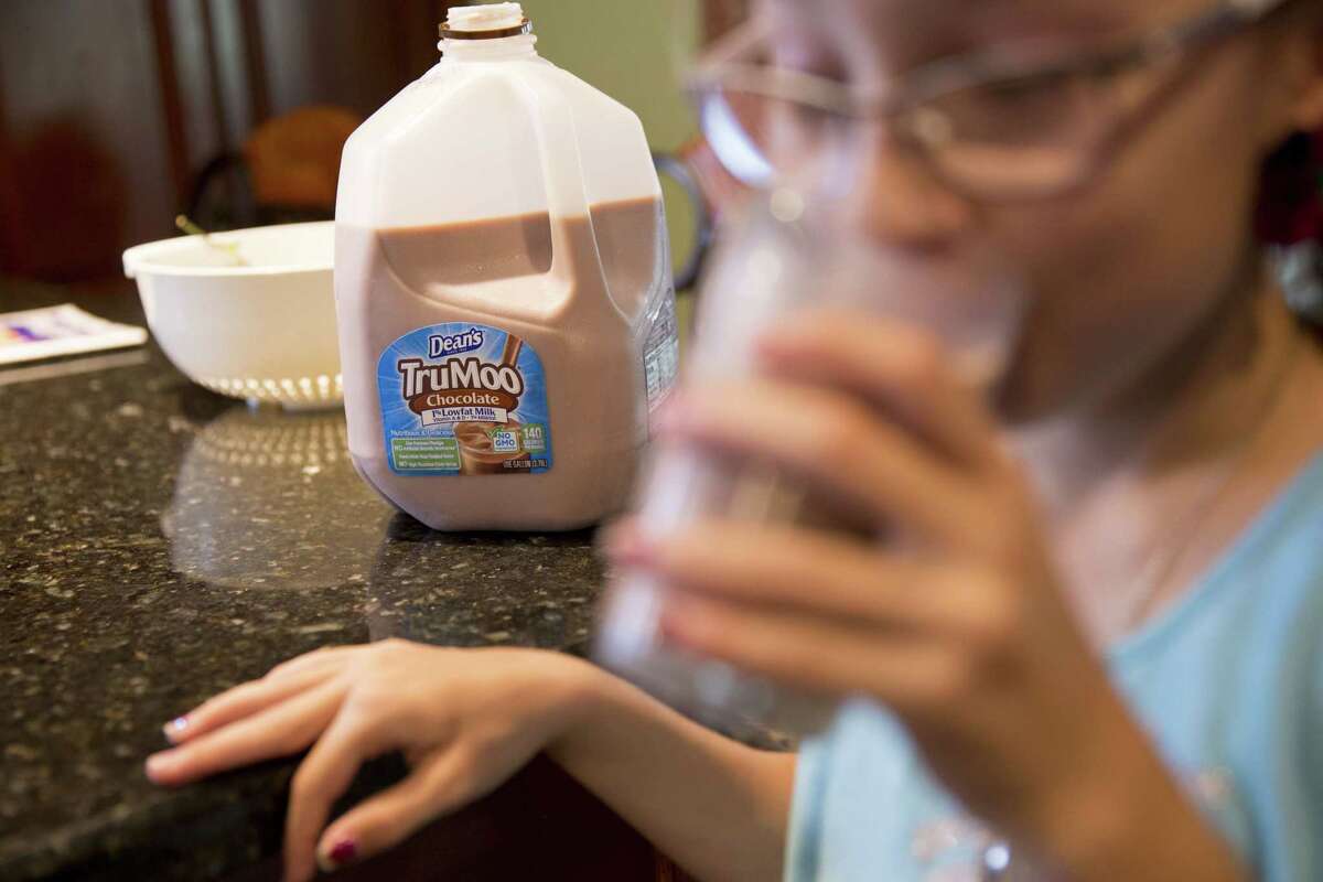 A girl drinks from a glass as a gallon of Dean Foods Co. Dean's TruMoo brand chocolate milk sits on a counter in an arranged photograph in Tiskilwa, Illinois, U.S., on Thursday, Aug. 3, 2017. Dean Foods Co. is scheduled to release earnings figures on August 8. Photographer: Daniel Acker/Bloomberg ORG XMIT: 775020000