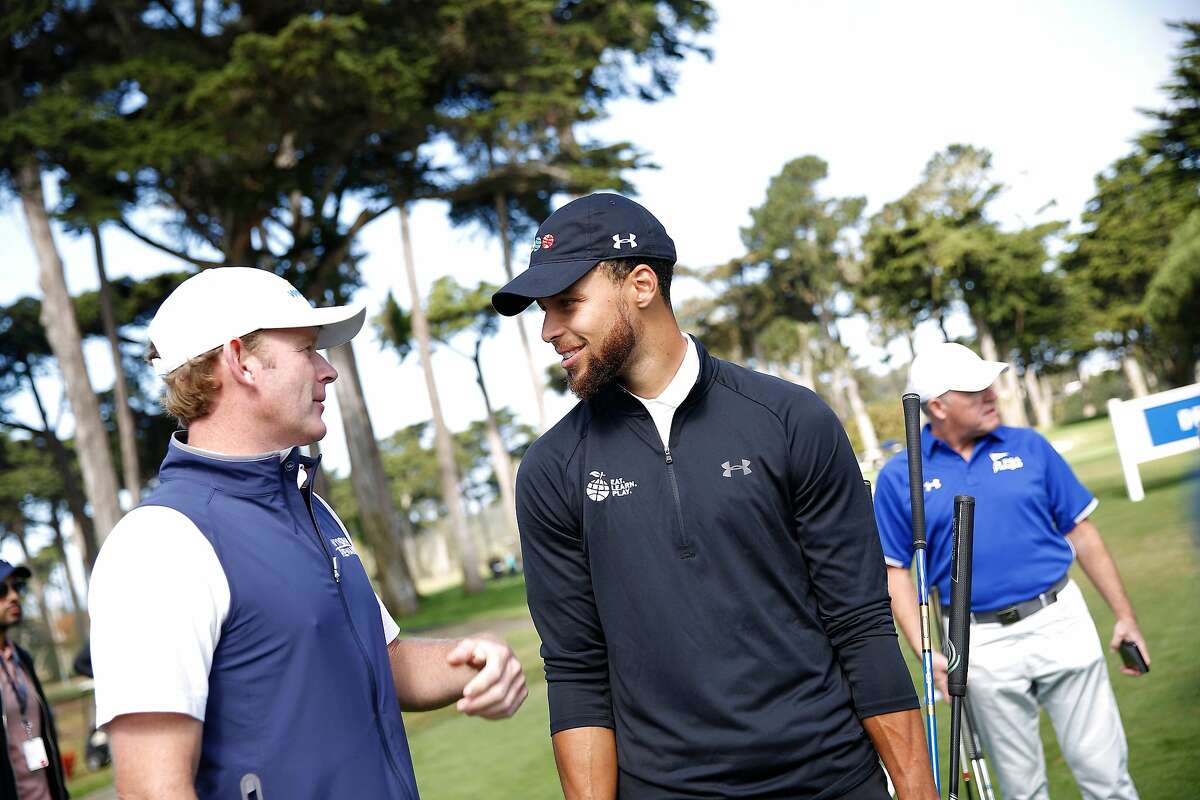 Warriors guard Stephen Curry (right) talks with tour pro Brandt Snedeker (left) during the skills challenge at the Steph Curry Charity Classic at Harding Park on Sept. 16, 2019.