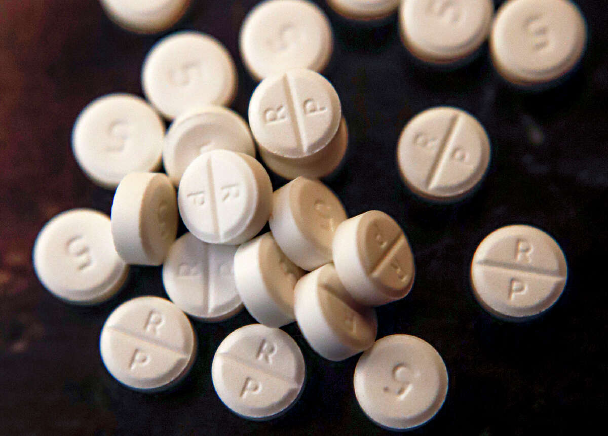 FILE - This Monday, June 17, 2019, file photo shows 5-mg pills of Oxycodone. While the nation's attorneys general debate a legal settlement with Purdue Pharma, the opioid epidemic associated with the company's blockbuster painkiller OxyContin rages on. The drugs still kill tens of thousands of people each year with no end in sight. (AP Photo/Keith Srakocic, File)