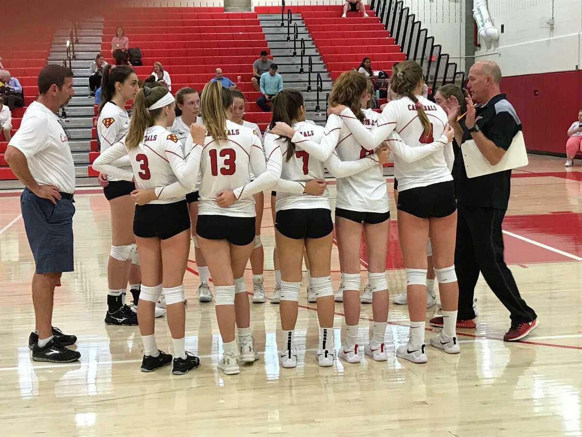 Coach Steve Lapham, far right, addresses the Greenwich High volleyball team after the first game of their match against Ridgefield on Monday, September 16, 2019, in Greenwich.