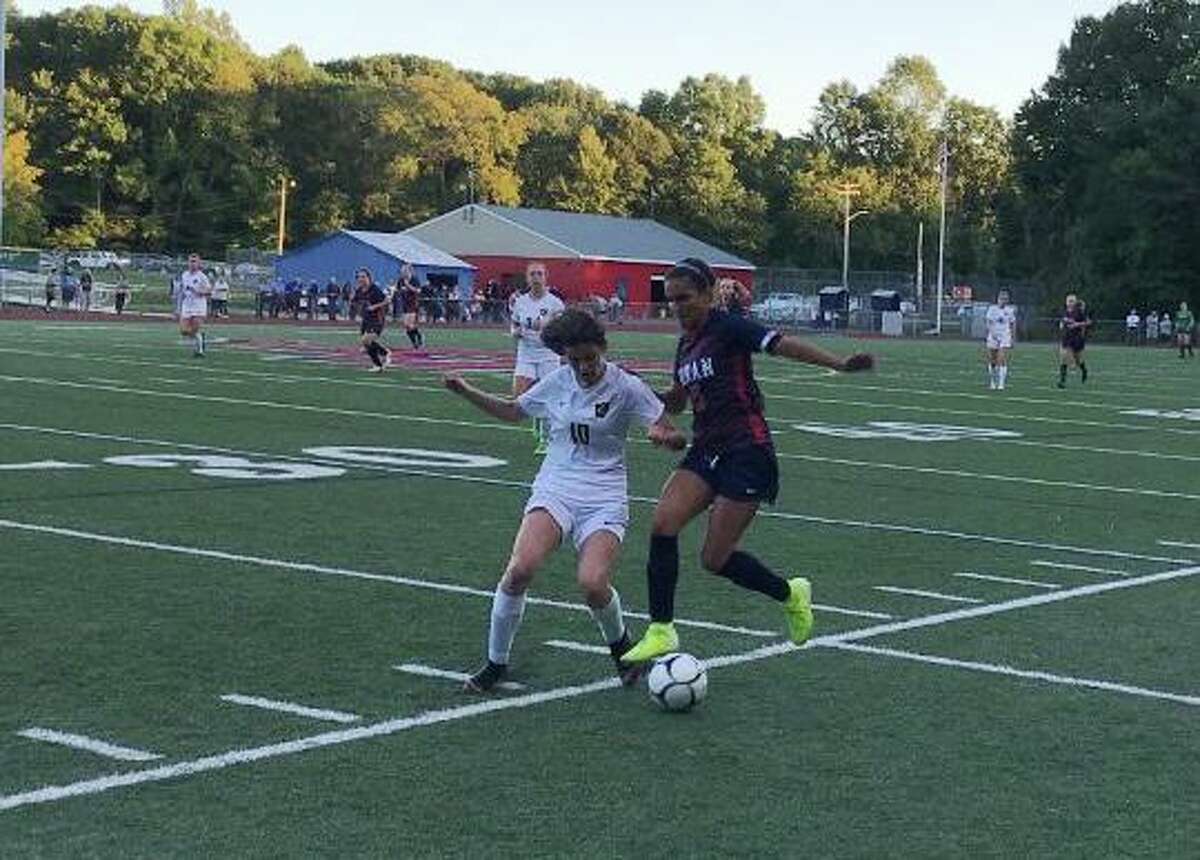 Jonathan Law's Brooke Dillman and Foran High's Ariana Montero battle for possession along the sideline.