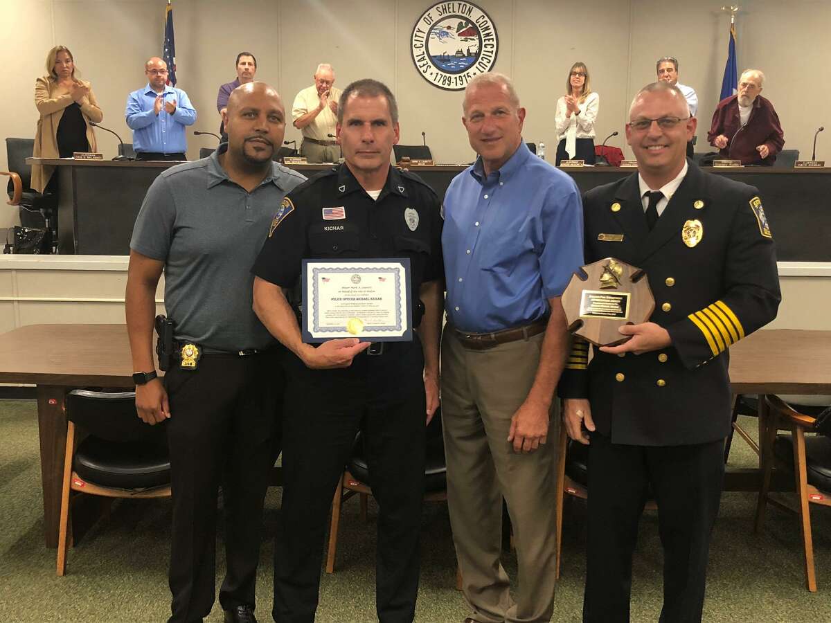 Shelton Police Officer Michael Kichar, second from left, was honored by Mayor Mark Lauretti for saving the lives of two people from their burning home in May. Pictured with Kichar are, left to right, police Chief Shawn Sequeira, Lauretti and Shelton Fire Chief Francis T. Jones III.