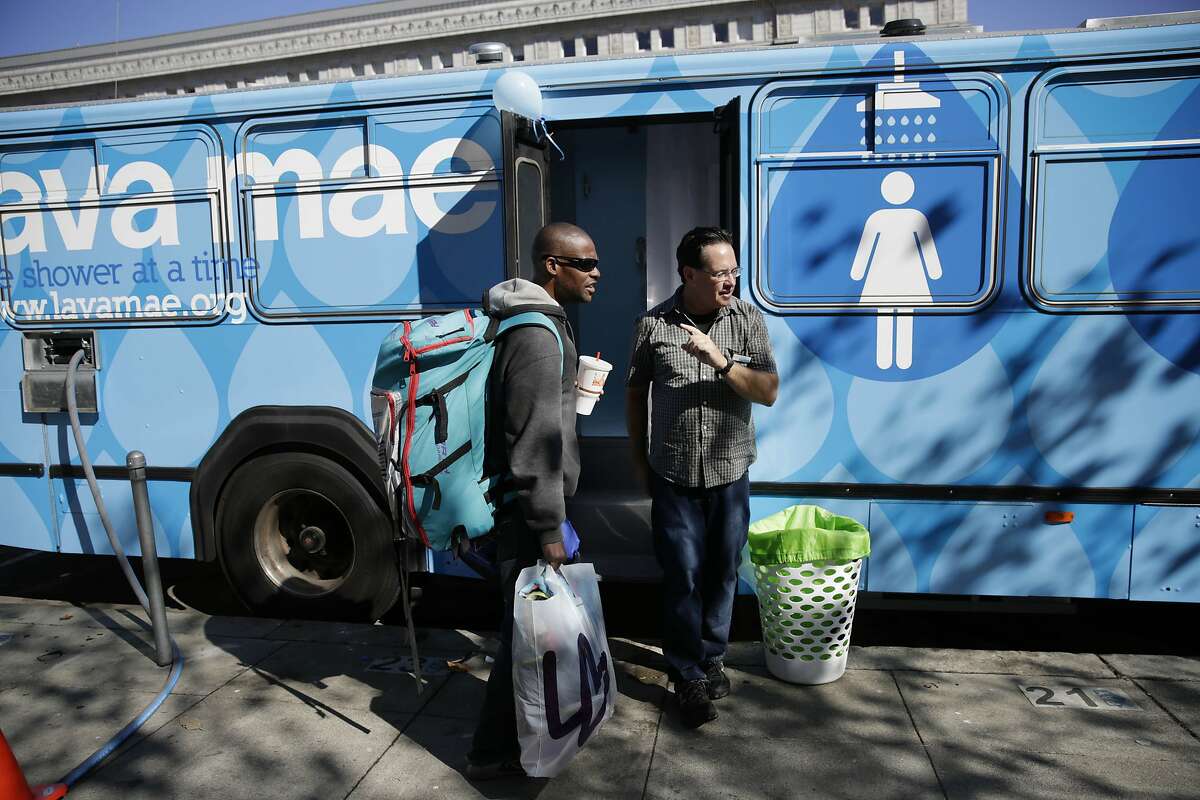 Raymond Thompson (l to r), who is homeless, is assisted by Michael McMorrow, mobile services manager, before taking a shower in the Lava Mae bus, on Tuesday, September 8, 2015 in San Francisco, Calif. Thompson says there aren't that many resources for people to clean up and that it gives people their privacy so that one doesn't have to be out in the open.