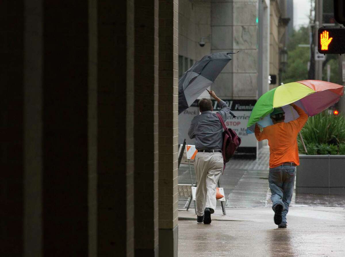 Pedestrians hold on to their umbrellas while crossing Fanning and Polk Streets as Tropical Storm Imelda is making its way across the Houston area during rush hour on Tuesday, Sept. 17, 2019, in downtown Houston.