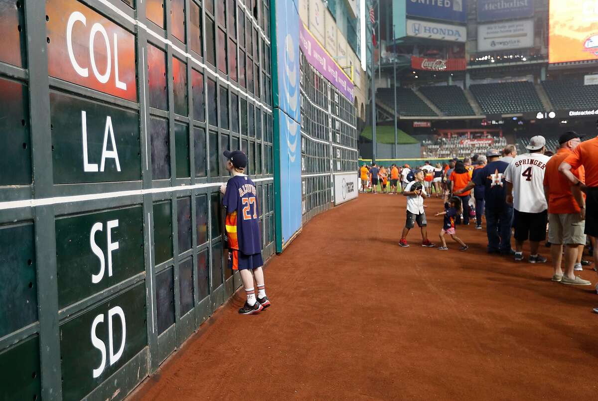 A kid peeks into the scoreboard under the Crawford Boxes as he and his family waited in line to get their photos taken in front of Tal's Hill in the outfield after an MLB game at Minute Maid Park, Sunday, Sept. 25, 2016 in Houston, before the center field renovations begin. The last opportunity for fans to get a photo will be after the game Wednesday after noon. Photo vouchers are required and all proceeds go to the Astros Foundation. ( Karen Warren / Houston Chronicle )