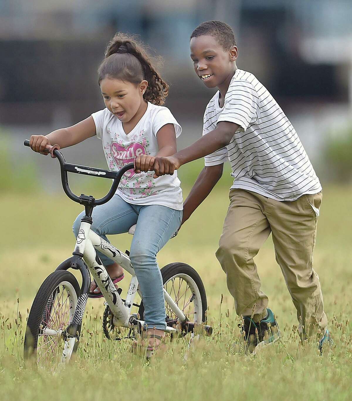 Naeem Jenkins, 10, teaches 5-year-old Kaylany Fargas how to ride a bike. We all need a little more kindness in our lives.