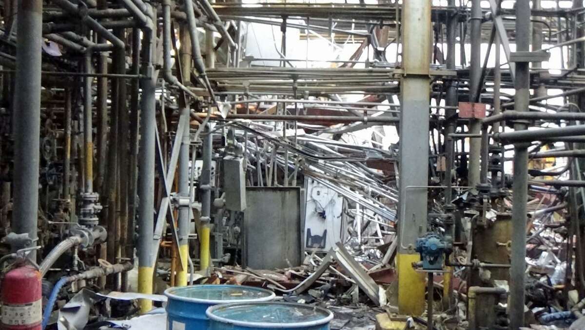 Post-incident photo of the April 2, 2019 fire showing the path KMCO workers commonly took to enter the plant building. With process units on the left and right, the walkway led to the entrance on the north side of the plant building, where emergency responders found the operator who died during the incident.