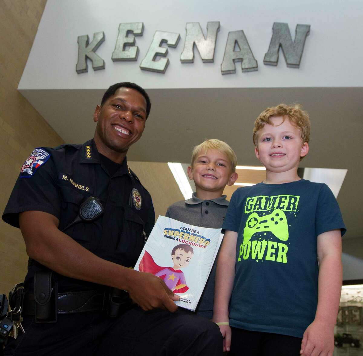 Montgomery ISD Police Chief Marlon Runnels, left, pose for a photo beside Keenan Elementary first grade students Lian Haverstock, center and Grayson Bishop recall hiding in a bathroom during a lockdown drill last year, Thursday, Sept. 12, 2019, in Montgomery. Bishop found Haverstock along in the hallway during the drill and the two decided to hide in the restroom for safety before being found by Runnels.
