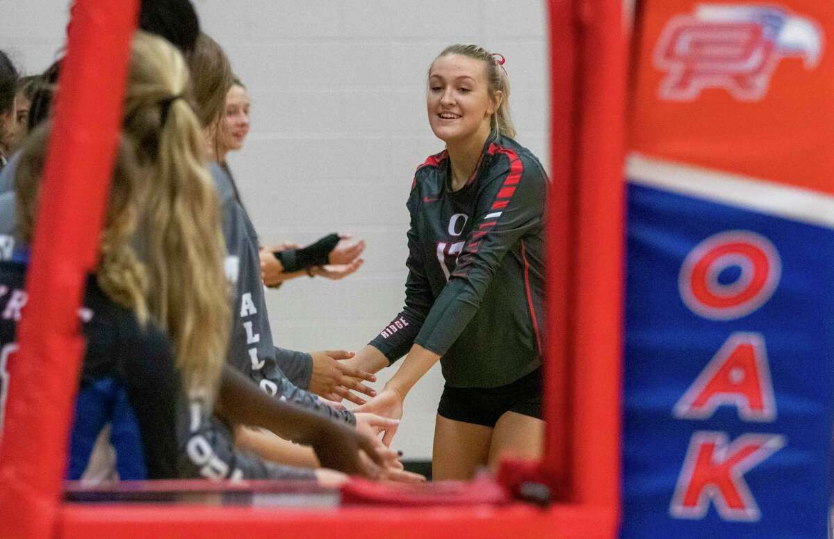 Oak Ridge senior Emma Smith (17) low fives teammates as her name is called during a district 15-6A volleyball match at Oak Ridge High School in Oak Ridge North.