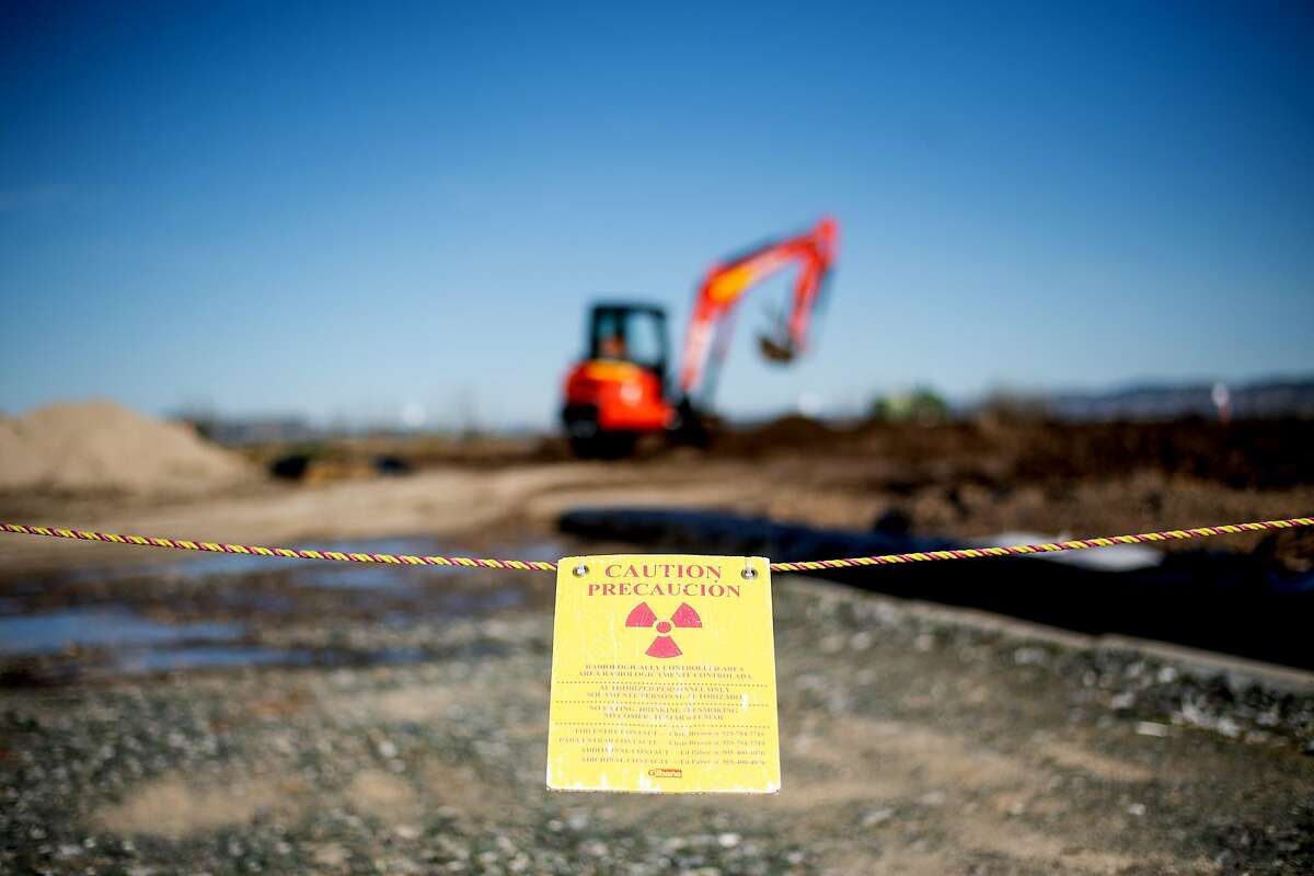 Workers prepare soil for radiation testing on Treasure Island on Tuesday, Feb. 19, 2019, in San Francisco, Calif. The parcel, gated off with radiation warning signs, sits near the Treasure Island Waste Water Treatment Plant along Avenue M.