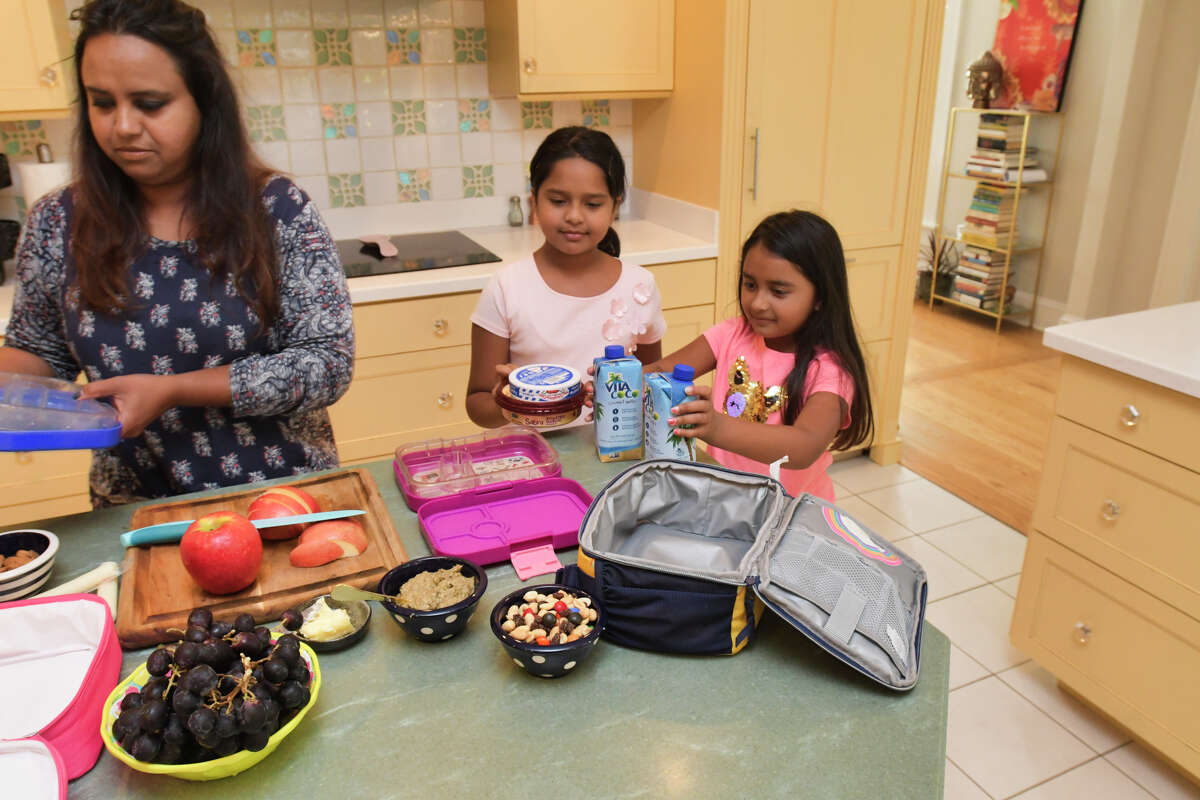 Aneesa Waheed and her daughters Zoya Shoaib, left, 8, and Suha Shoaib, 7, work together to make the girl's school lunches on Monday, Sept. 16, 2019, at their home in Niskayuna, N.Y. (Paul Buckowski/Times Union)