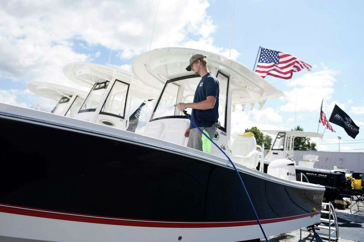 Ralph Arcamone, of All Seasons Marine Works, cleans a Regulator 26XO in preparation for the Progressive Insurance Norwalk Boat Show at Cove Marina in Norwalk, Thursday.