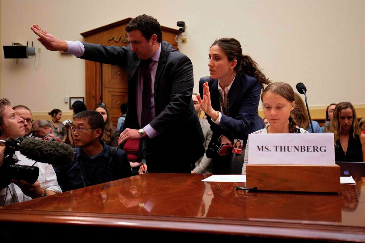Swedish environment activist Greta Thunberg (R) looks on as staffers attempt to usher photographers away during a joint hearing before the House Foreign Affairs Committee, Europe, Eurasia, Energy and the Environment Subcommittee, and the House Select Committee on the Climate Crisis, at the Rayburn House Office Building on Capitol Hill in Washington, DC, on September 18, 2019. (Photo by Alastair Pike / AFP)ALASTAIR PIKE/AFP/Getty Images