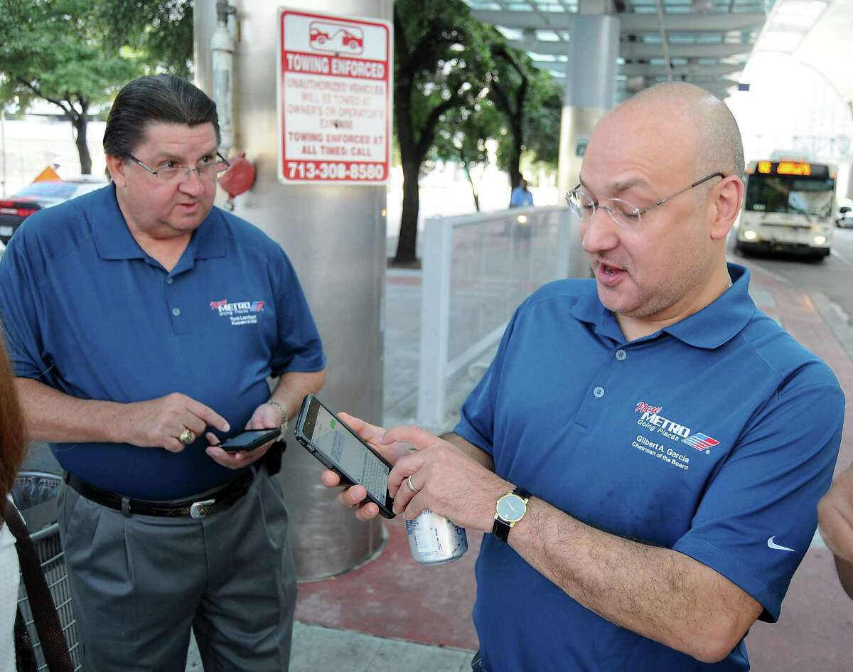 Metropolitan Transit Authority CEO Tom Lambert and former Metro chairman Gilbert Garcia use the new app to check arrival times for buses at the Downtown Transit Center on Aug.16, 2015. Garcia, who led the agency for five years, is an opponent of the upcoming transit plan election.
