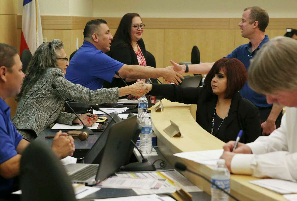 Stacey Estrada (right) shakes hands with South San Board President Connie Prado and Kevin Rasco (right) shakes hands with Trustee Gilbert F. Rodriguez as Estrada and Roscoe were voted in as trustees during the South San school board meeting on Wednesday, Sept. 18, 2019. Estrada and Roscoe replaced two of the three trustees who abruptly resigned recently. (Kin Man Hui/San Antonio Express-News)