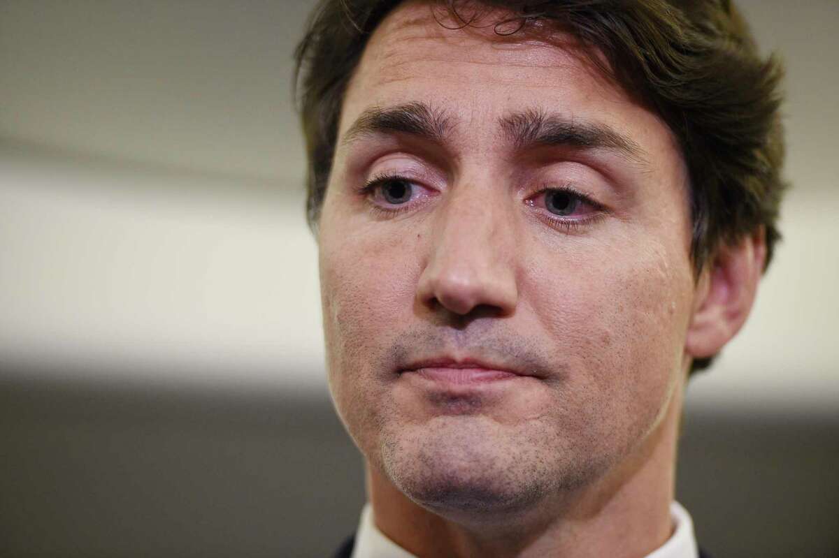 Canadian Prime Minister and Liberal Party leader Justin Trudeau reacts as he makes a statement in regards to a photo coming to light of himself from 2001, wearing "brownface," during a scrum on his campaign plane in Halifax, Nova Scotia, Wednesday, Sept. 18, 2019. (Sean Kilpatrick/The Canadian Press via AP)