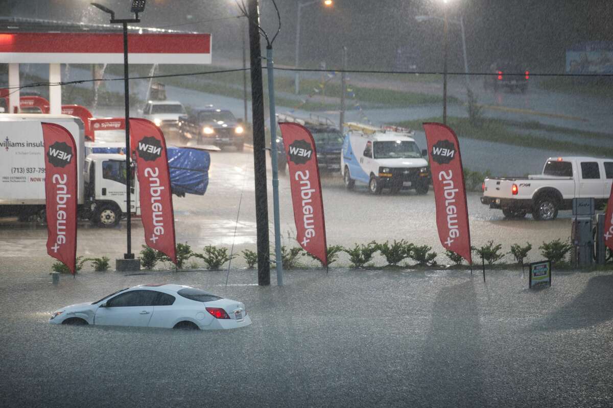 A flooded out car is stranded in high water off U.S. 59 as rain from Tropical Depression Imelda inundates the area on Thursday, Sept. 19, 2019, near Spendora.