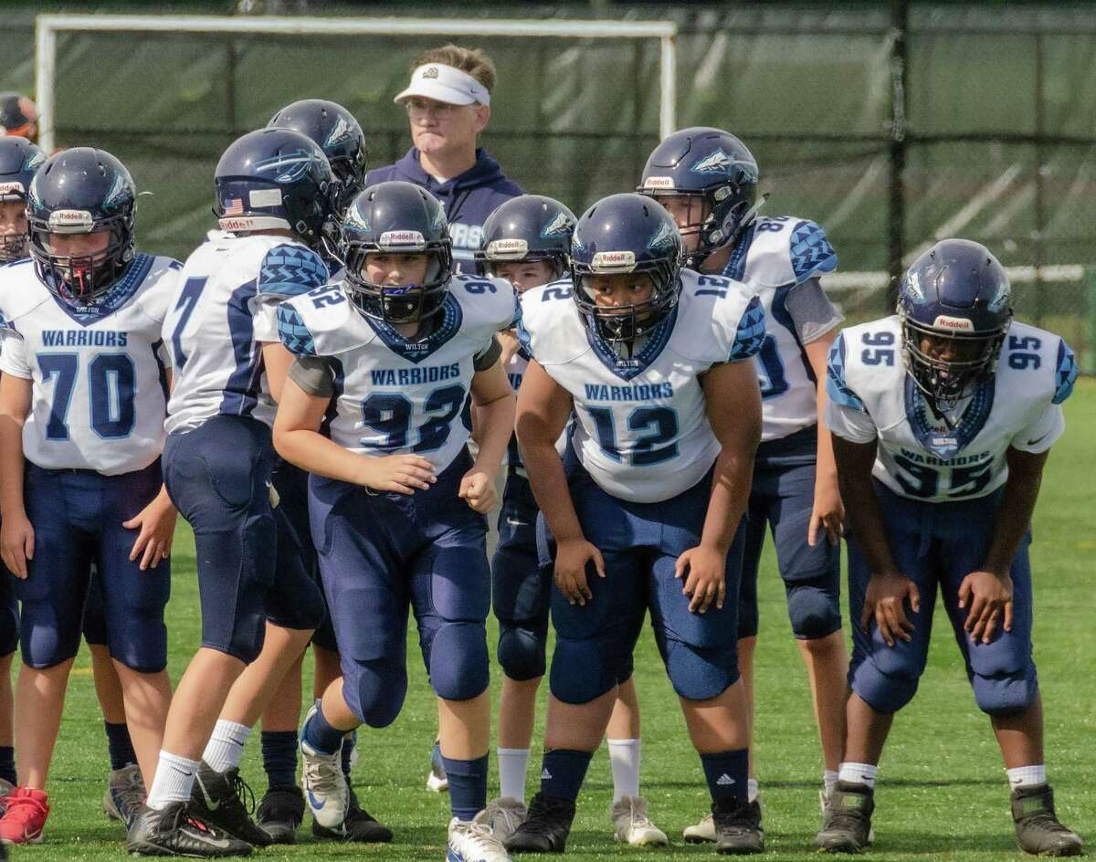 CJ Young (#70), Cael Dexter (#7), Jack Huntley (#92), Jaxon Thomas (#12), Liam McKiernan (#80), and Maja Driscoll (#95) on the field for the Wilton Blue 7th grade team.