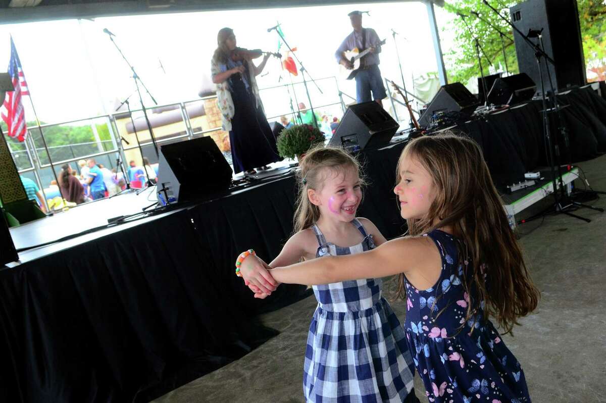 Penelope Prue, 5, left, and her friend Aria fiakos, 5, both of Milford, dance together to the music of Ringrose and Freeman during the annual Milford Irish Festival in Milford, Conn.