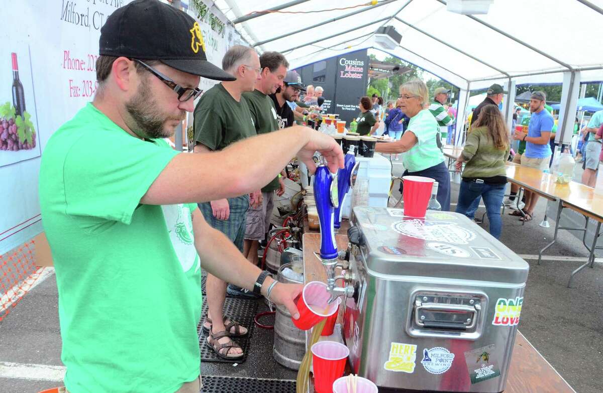Chris Willett, with Milford Point Brewing, pours a beer during the annual Milford Irish Festival in Milford, Conn., on Friday Sept. 5, 2019.