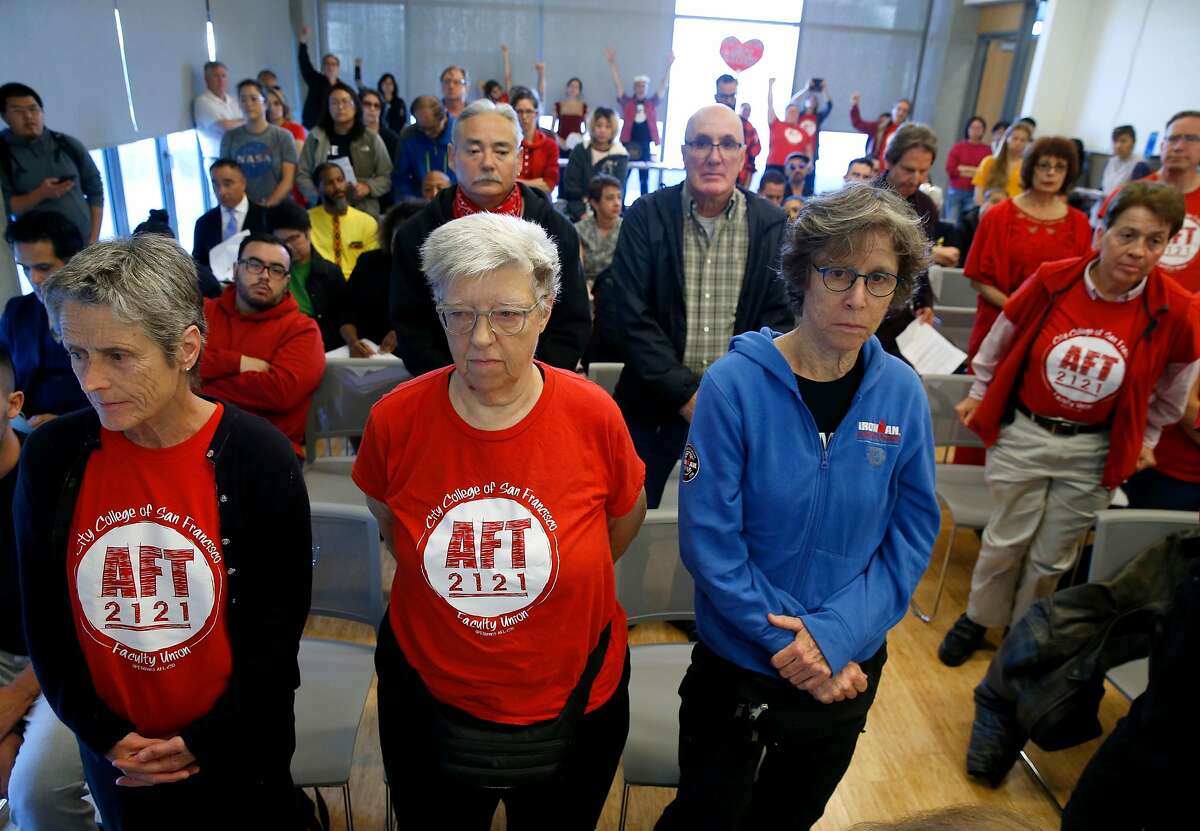 Faculty and students stand to show disapproval of a proposed pay raise for college executives at a meeting of the CCSF Board of Trustees Budget and Audit Committee at the Chinatown campus in San Francisco, Calif. on Thursday, Sept. 19, 2019.